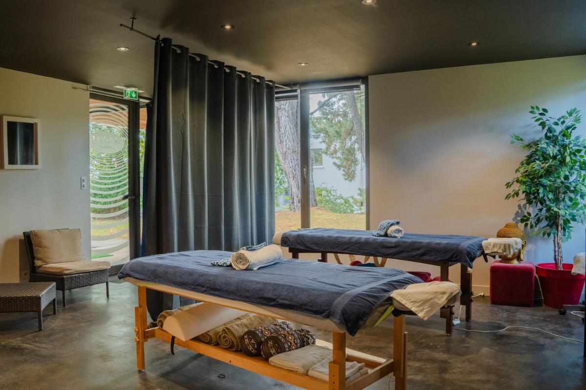 deux lits dans une chambre avec une fenêtre dans l'établissement Le Galet Hotel & Spa, à Saint-Philibert