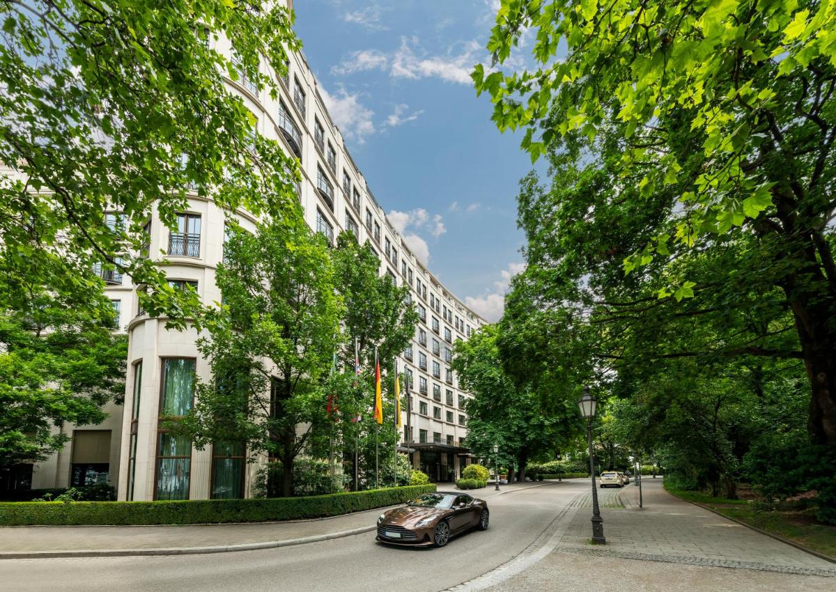 ein Auto, das eine Straße entlang fährt, neben einem Gebäude in der Unterkunft Rocco Forte The Charles Hotel in München ein Auto, das eine Straße entlang fährt, neben einem Gebäude in der Unterkunft Rocco Forte The Charles Hotel in München