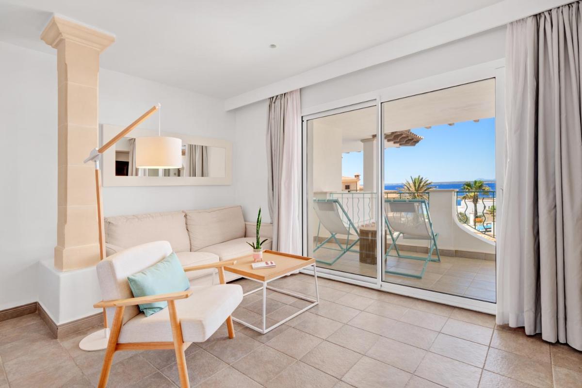 Una sala de estar con un sofá y un balcón. en Hotel Villa Chiquita - Adults Only - Over 12, en Colonia de Sant Jordi