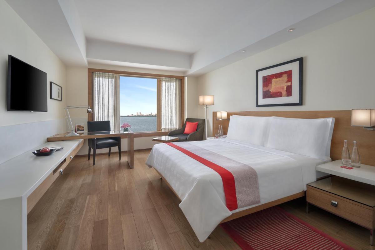 a hotel room with a bed and a desk with a computer at Trident Nariman Point in Mumbai a hotel room with a bed and a desk with a computer at Trident Nariman Point in Mumbai