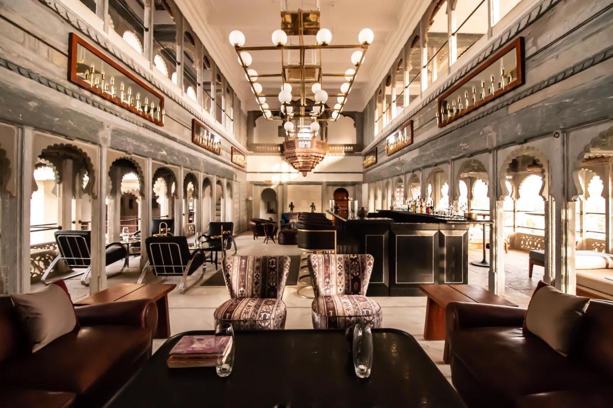 a restaurant with couches and chairs in a room at RAAS Devigarh in Udaipur