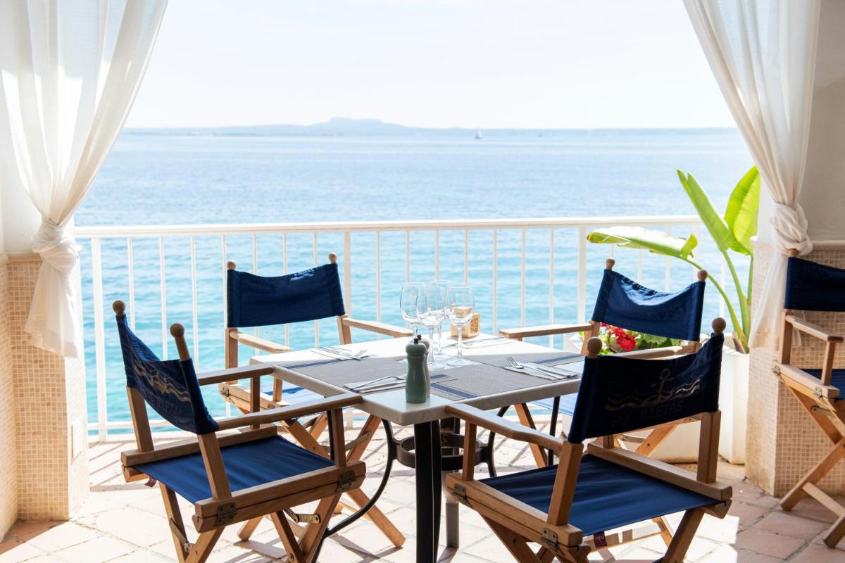 Una mesa y sillas en un balcón con vista al mar. en Hotel ROC Illetas & SPA, en Illetas