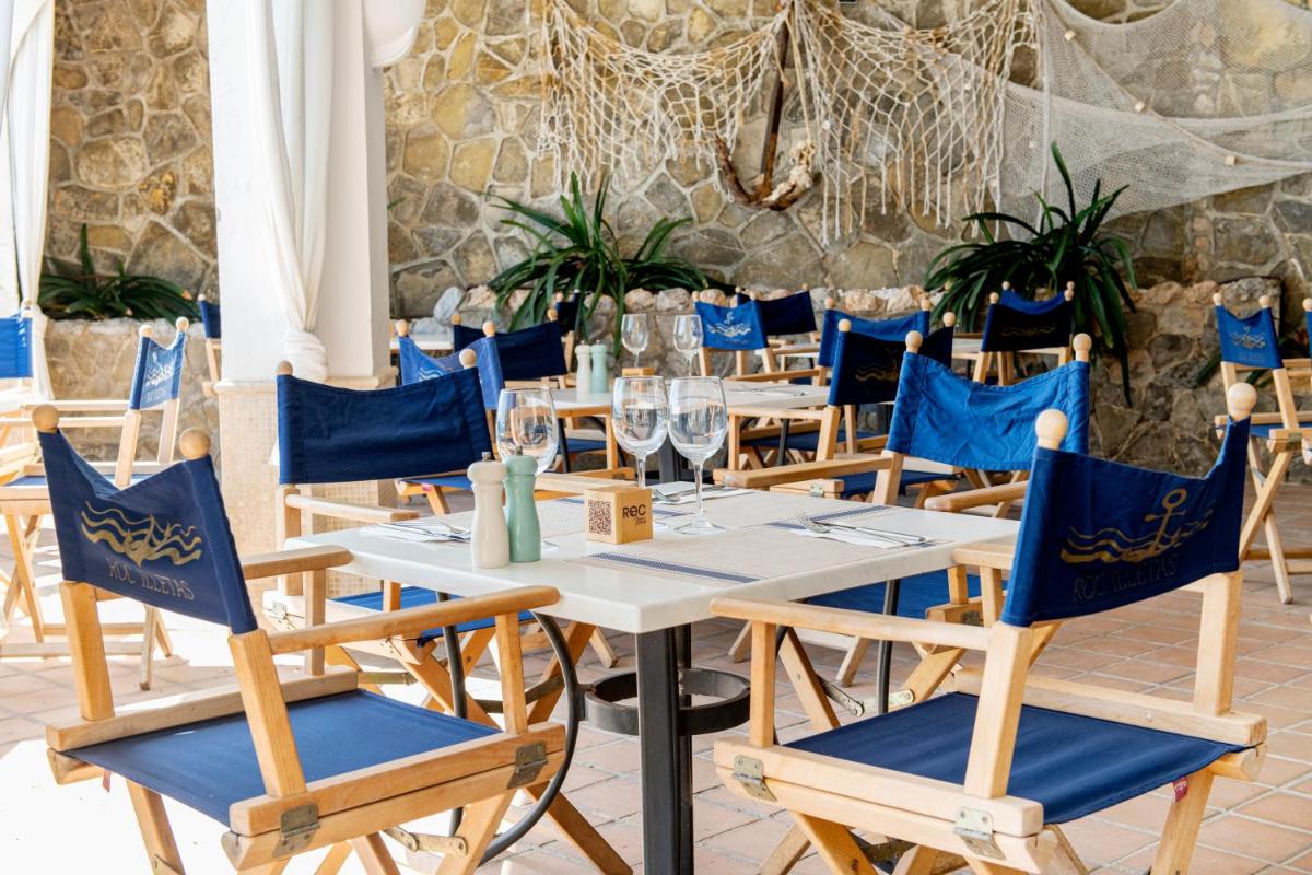 comedor con sillas azules y mesa en Hotel ROC Illetas & SPA, en Illetas