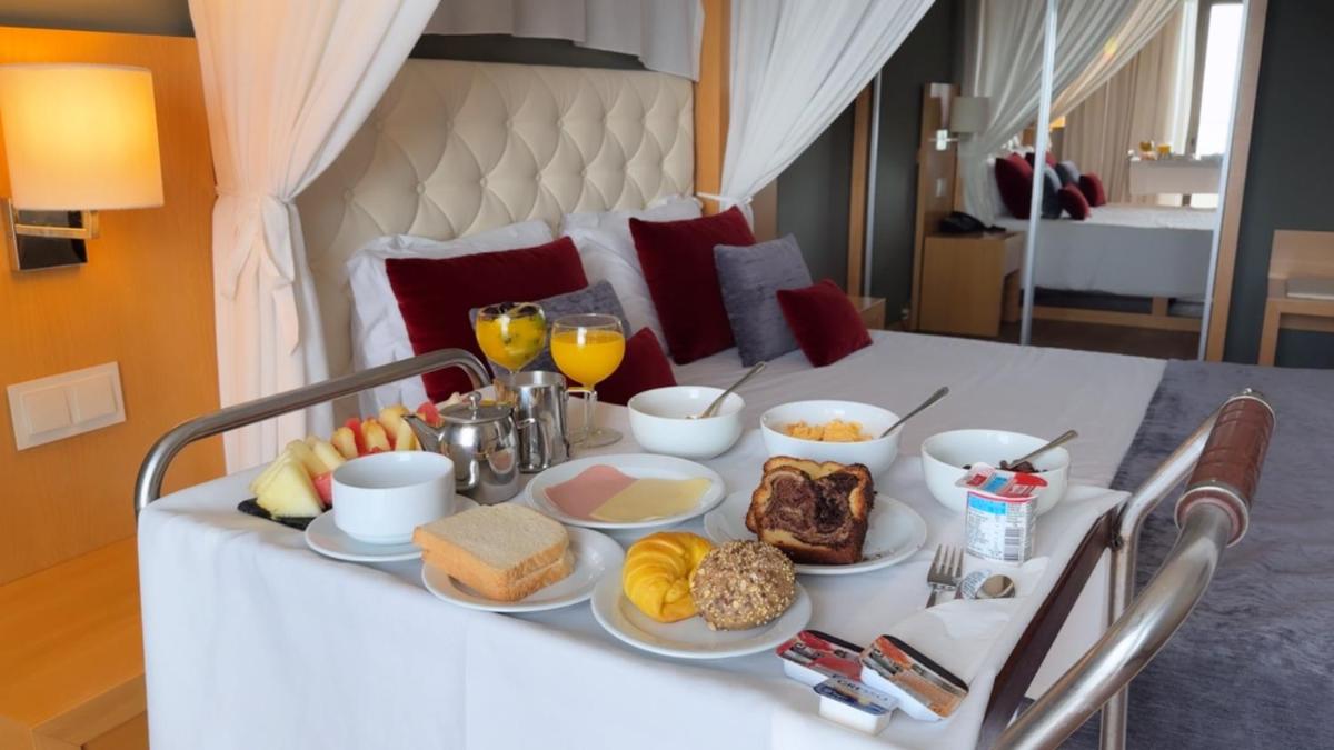 uma mesa com comidas e bebidas para o café da manhã em Hotel Atlantida Sol na Figueira da Foz