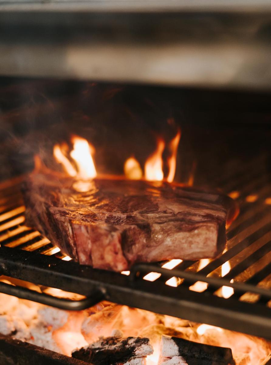 un pedazo de carne se está cocinando en un horno en Hotel Palau Fugit, en Girona