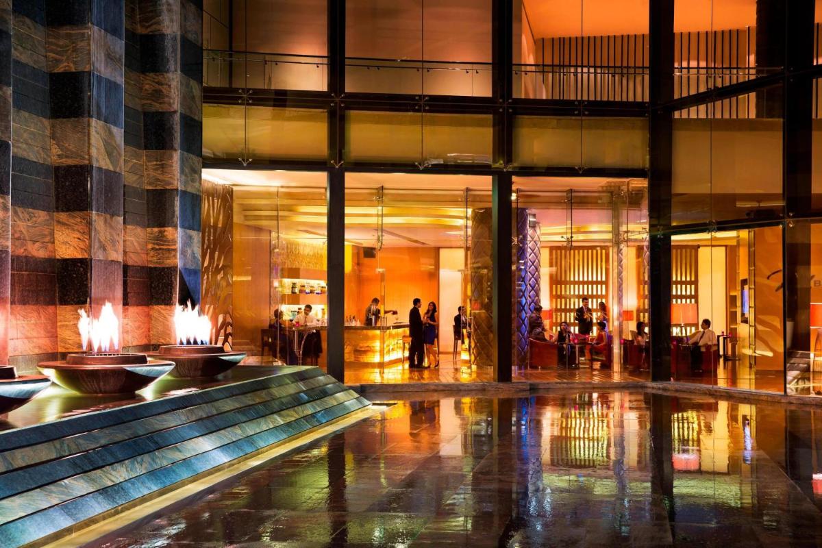 a lobby with a fountain in the middle of a building at Bengaluru Marriott Hotel Whitefield in Bengaluru
