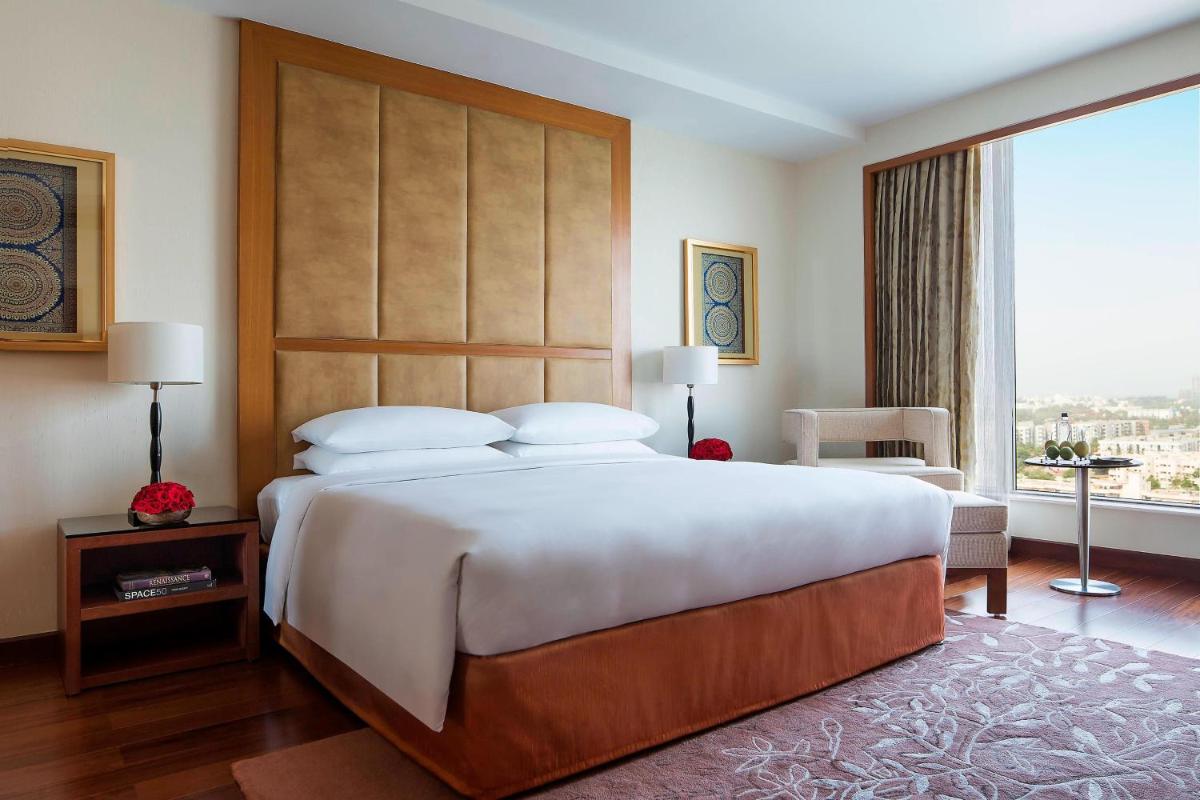 a bedroom with a large bed and a large window at Bengaluru Marriott Hotel Whitefield in Bengaluru