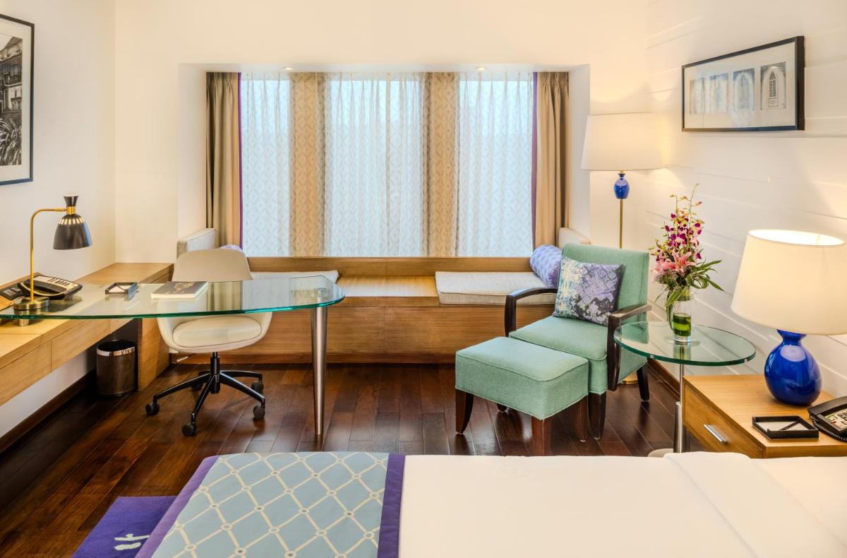 a hotel room with a bed and a desk at Vivanta Goa, Panaji in Panaji a hotel room with a bed and a desk at Vivanta Goa, Panaji in Panaji