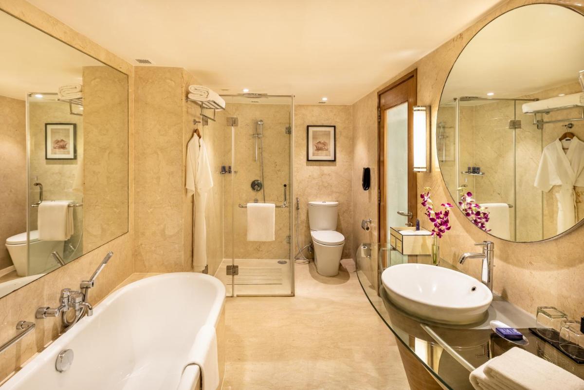 a bathroom with a tub and a sink and a shower at Vivanta Goa, Panaji in Panaji a bathroom with a tub and a sink and a shower at Vivanta Goa, Panaji in Panaji