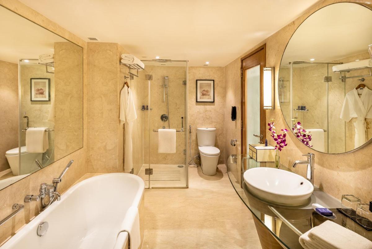 a bathroom with a tub and a toilet and a sink at Vivanta Goa, Panaji in Panaji a bathroom with a tub and a toilet and a sink at Vivanta Goa, Panaji in Panaji