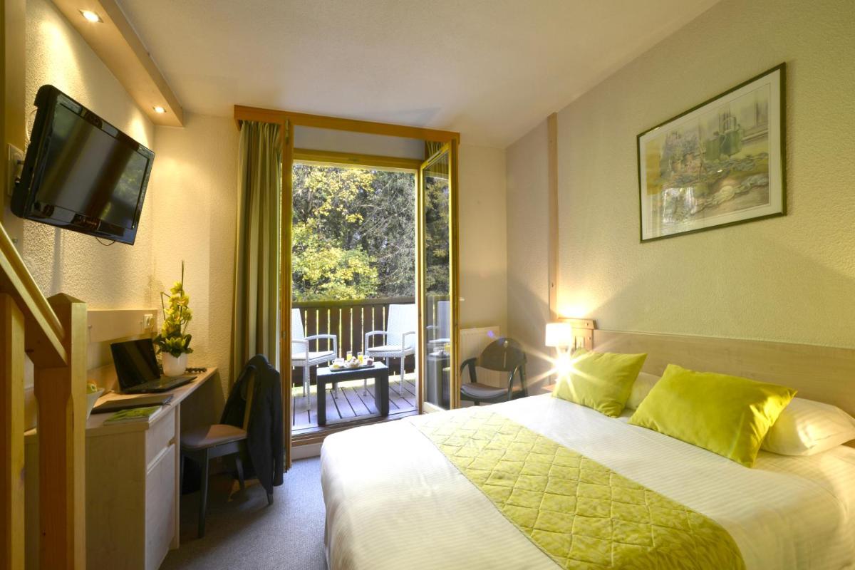 une chambre d'hôtel avec un lit et une télévision dans l'établissement Le Bois Dormant-Hôtel Restaurant & Spa Logis Hôtel, à Champagnole 54 autres photos