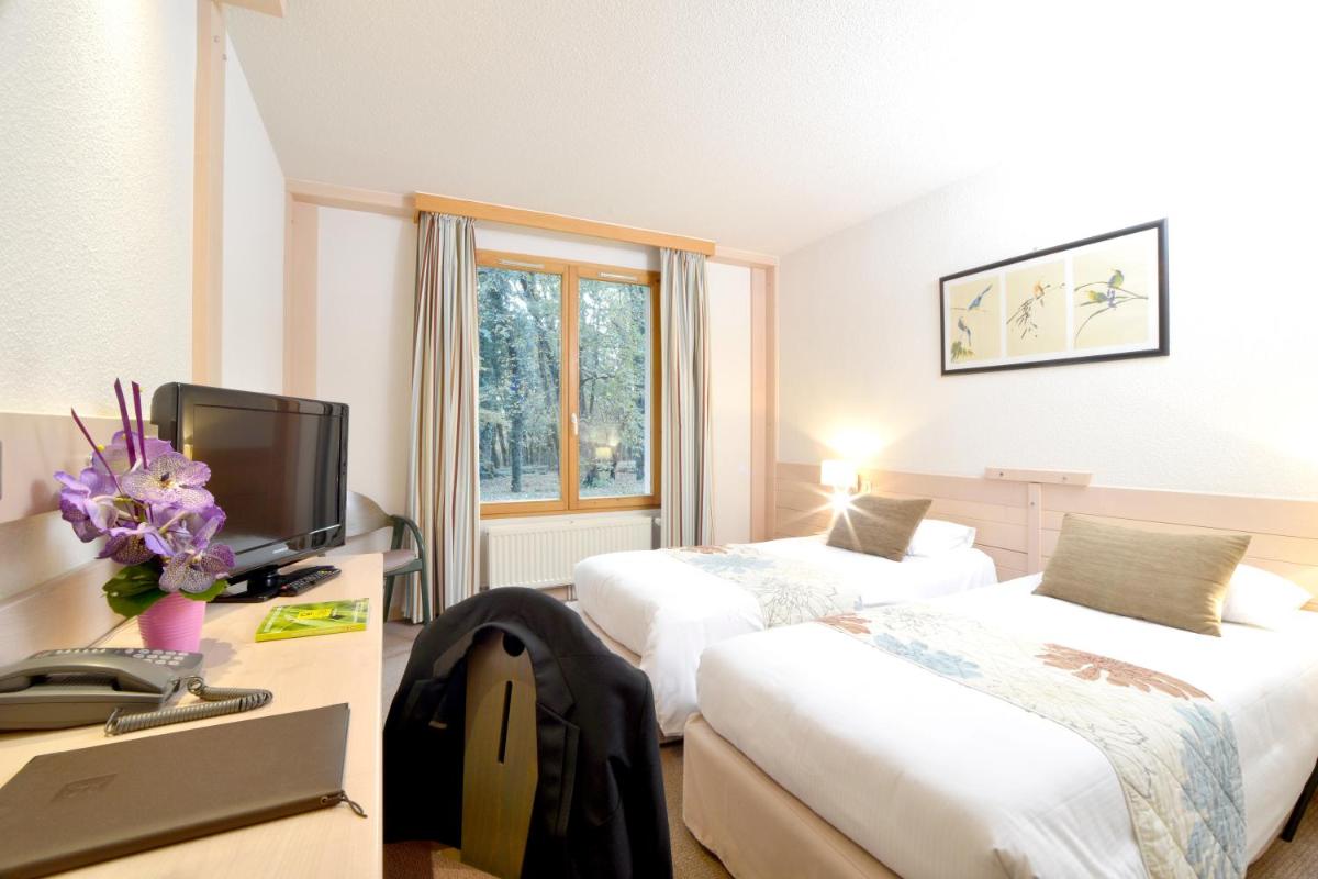 Un ou plusieurs lits dans un hébergement de l'établissement Le Bois Dormant-Hôtel Restaurant & Spa Logis Hôtel