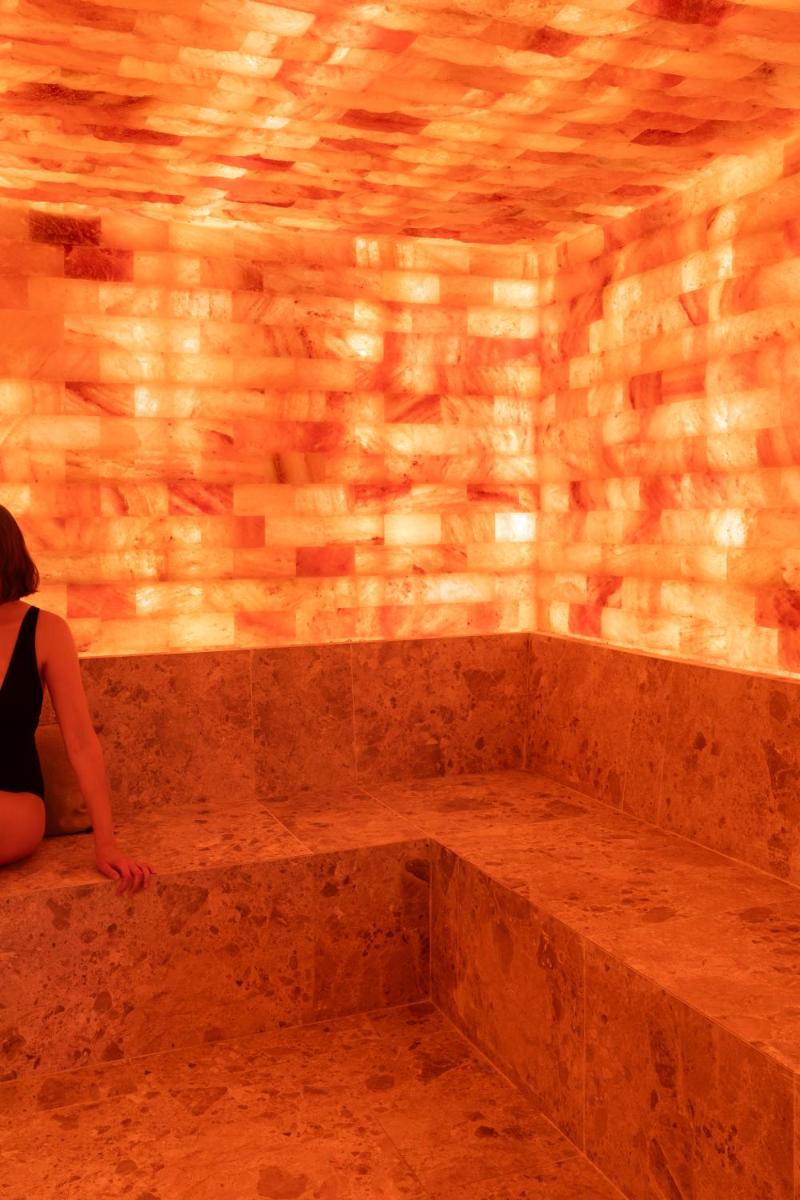 une femme assise sur un banc en pierre dans une pièce dans l'établissement Le Couvent des Minimes, un Hôtel & Spa L'Occitane en Provence, à Mane 138 autres photos