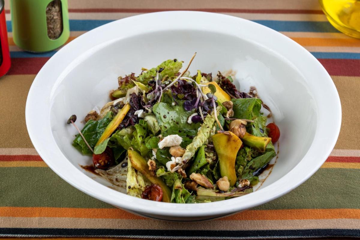 a white bowl filled with a salad on a table at Holiday Inn New Delhi Aerocity by IHG in New Delhi