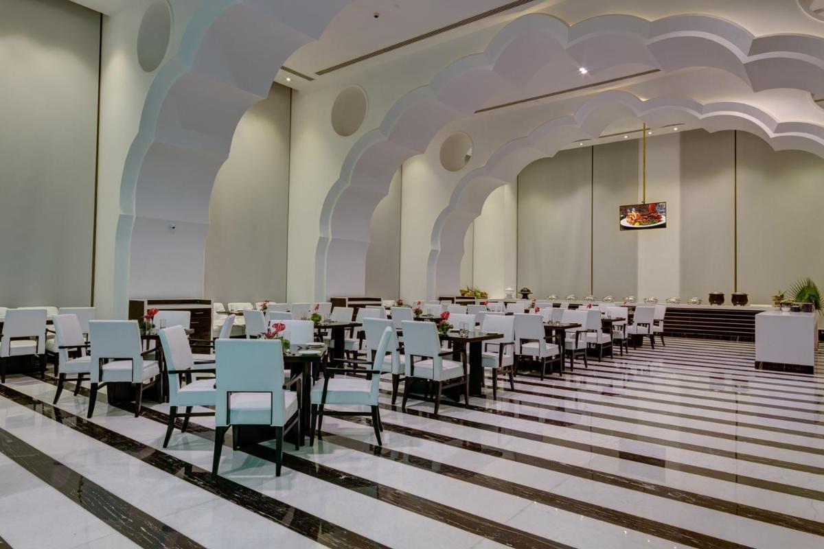 a banquet hall with white tables and chairs at Saura Hotel, Agra - A Club Mahindra Associate in Agra