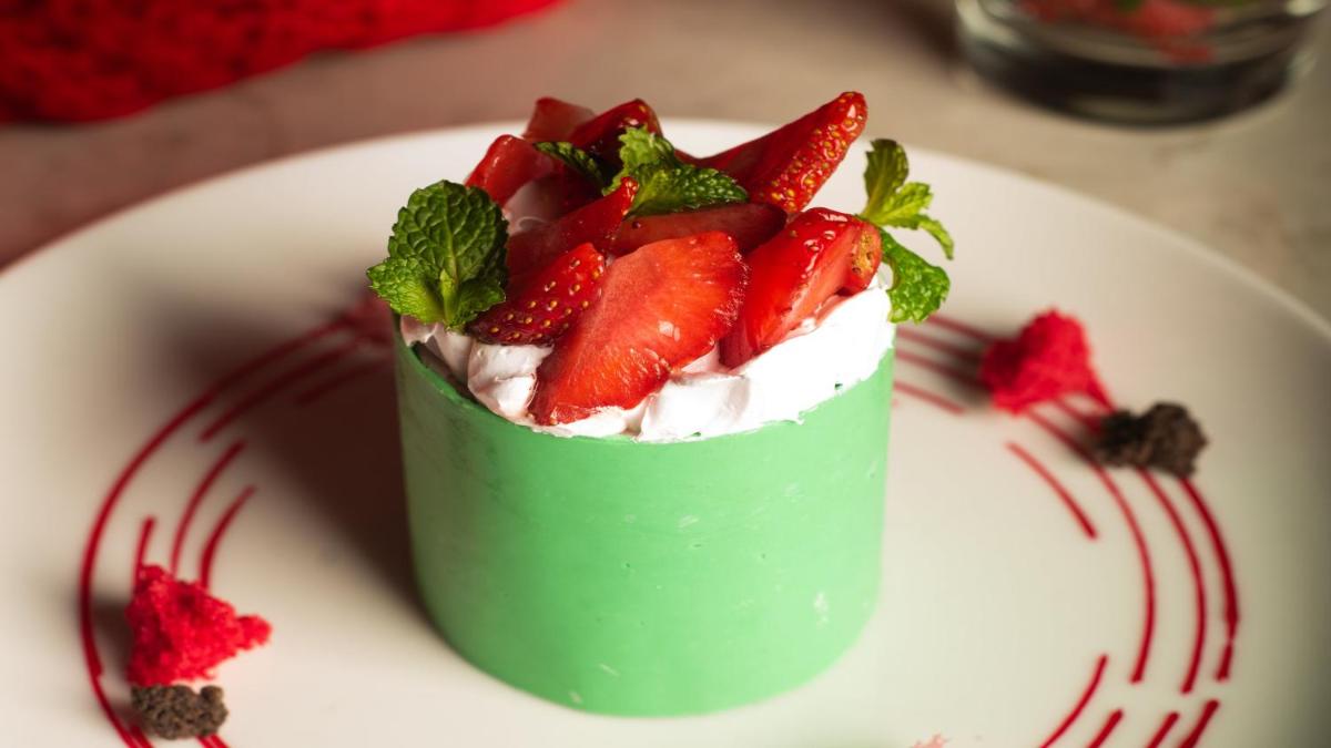 a green dessert with strawberries on a white plate at Holiday Inn New Delhi Aerocity by IHG in New Delhi