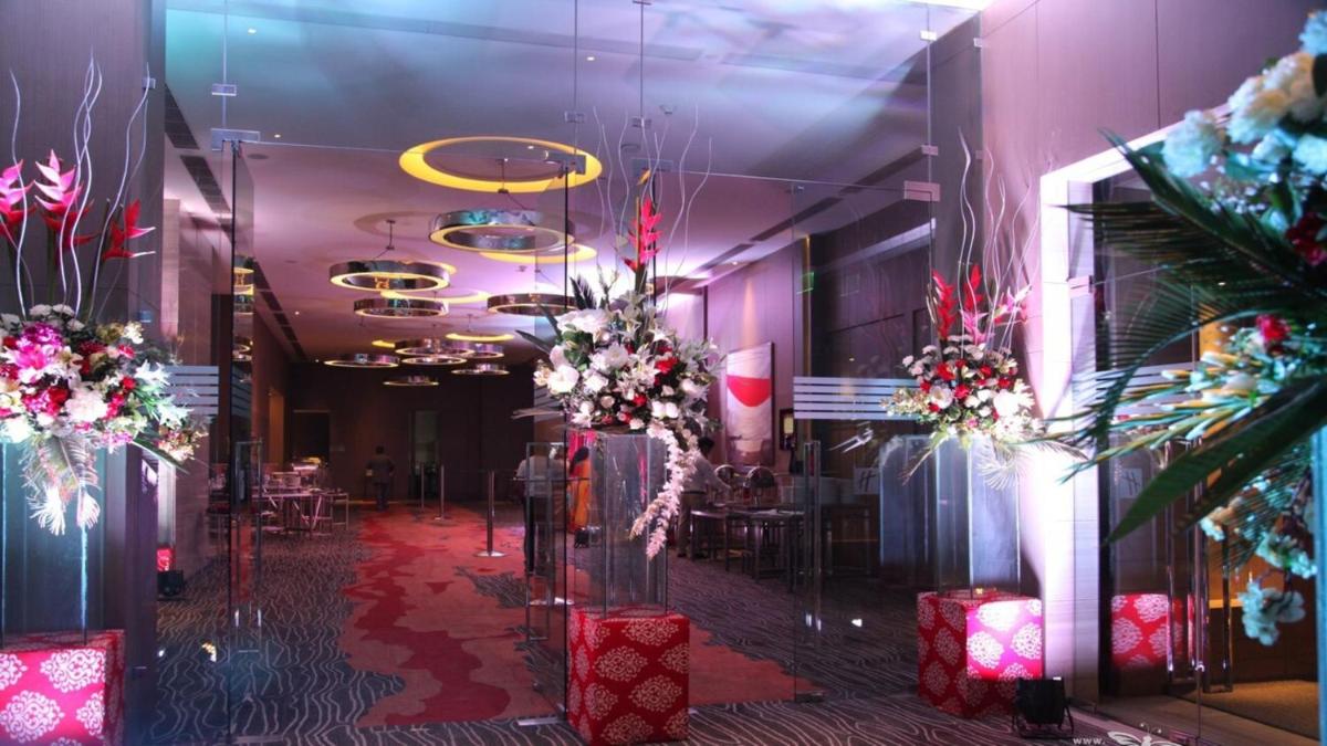 a room with pink walls and flowers and tables at Holiday Inn New Delhi Aerocity by IHG in New Delhi