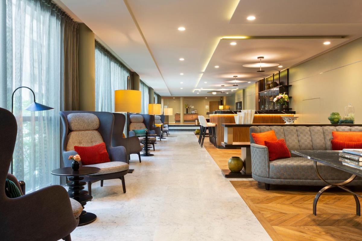 - une salle d'attente avec des canapés et des chaises dans un hôpital dans l'établissement La Clef Tour Eiffel Paris by The Crest Collection, à Paris
