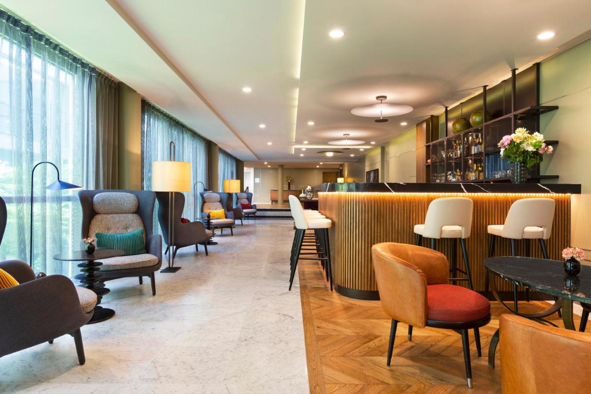 - un hall doté d'un bar avec des chaises et des tables dans l'établissement La Clef Tour Eiffel Paris by The Crest Collection, à Paris
