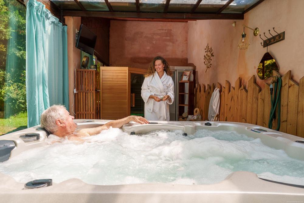 une femme debout à côté d'un homme dans une baignoire dans l'établissement Hôtel Le Mas des Grès & Restaurant Sous les Platanes, à Lagnes
