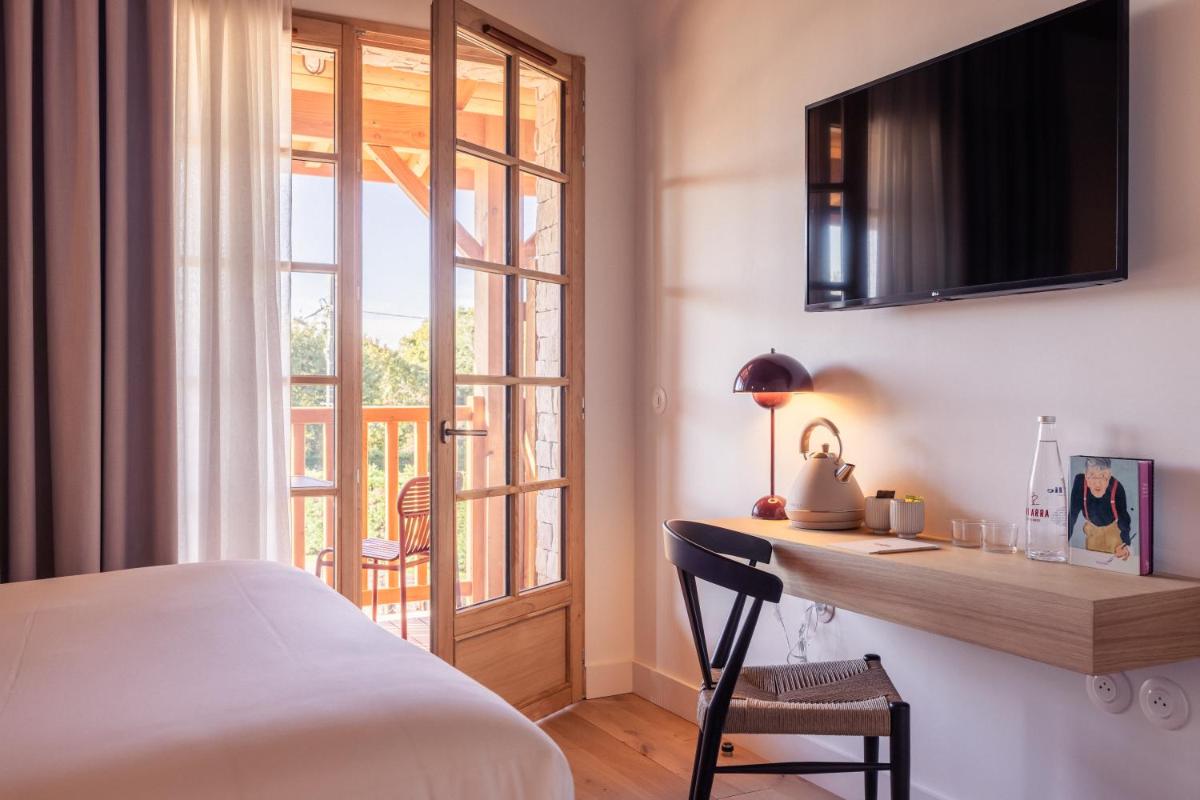 une chambre avec un lit, un bureau et une fenêtre dans l'établissement Hôtel INDARRA & SPA - Piscine, à Arbonne