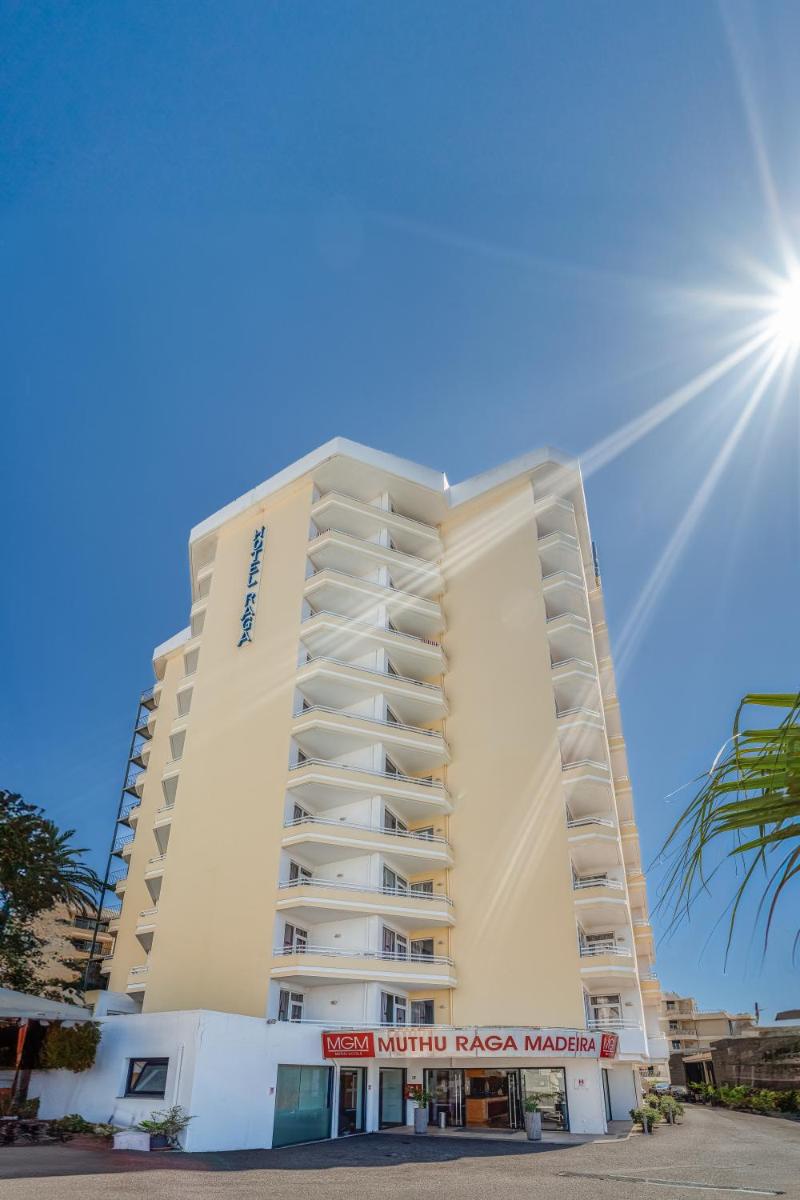um prédio de hotel branco com o sol no céu em Muthu Raga Madeira Hotel no Funchal