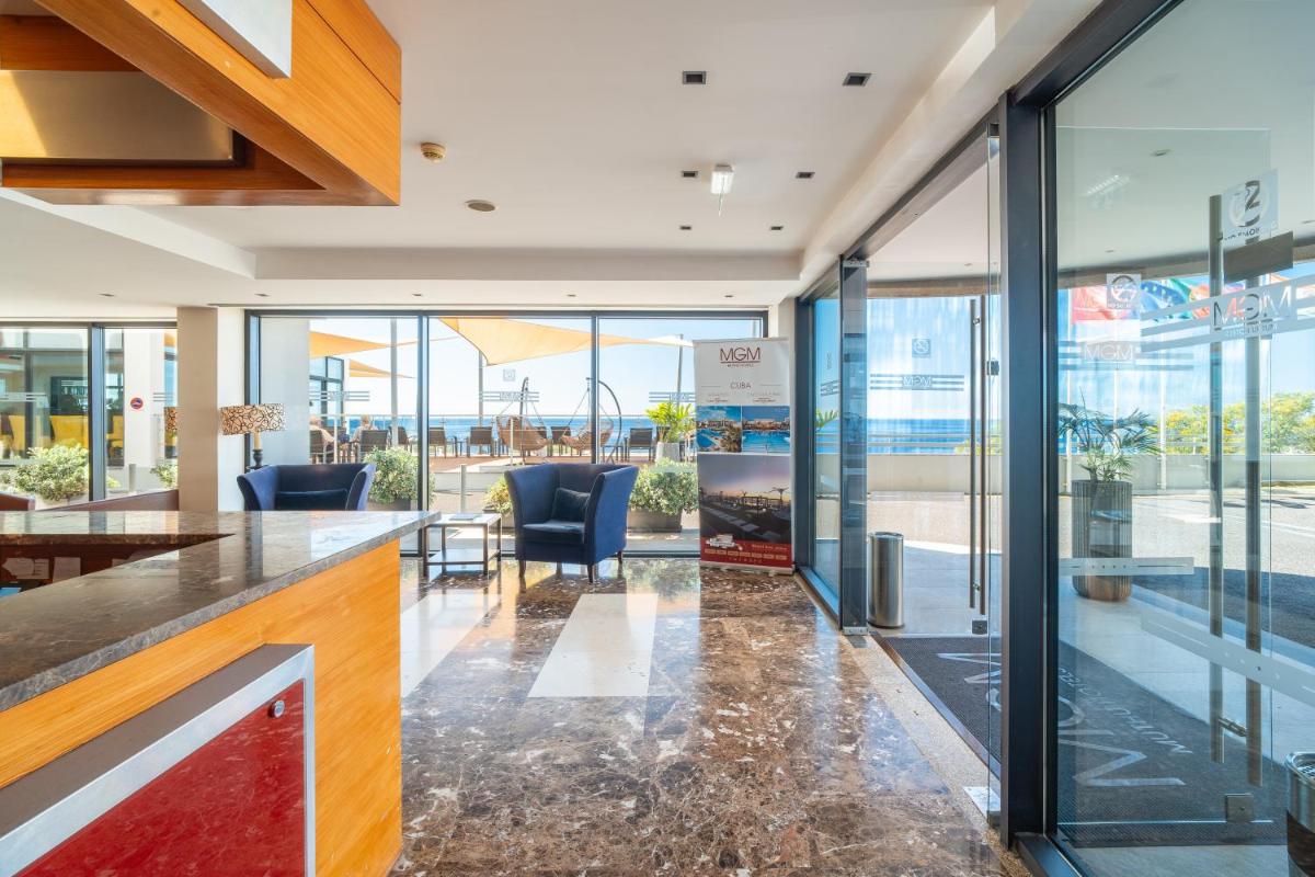um átrio com um bar com cadeiras e janelas em Muthu Raga Madeira Hotel no Funchal