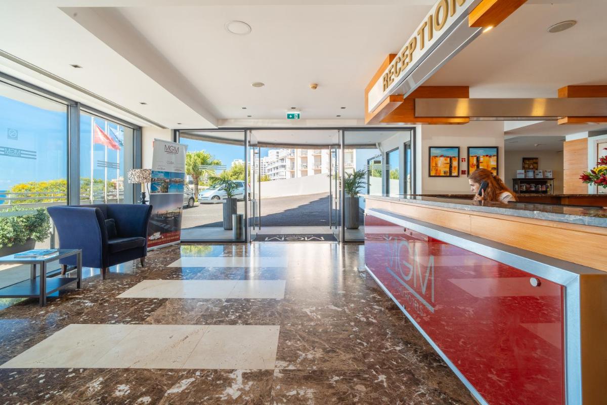 um átrio com um bar com um cão sentado no balcão em Muthu Raga Madeira Hotel no Funchal