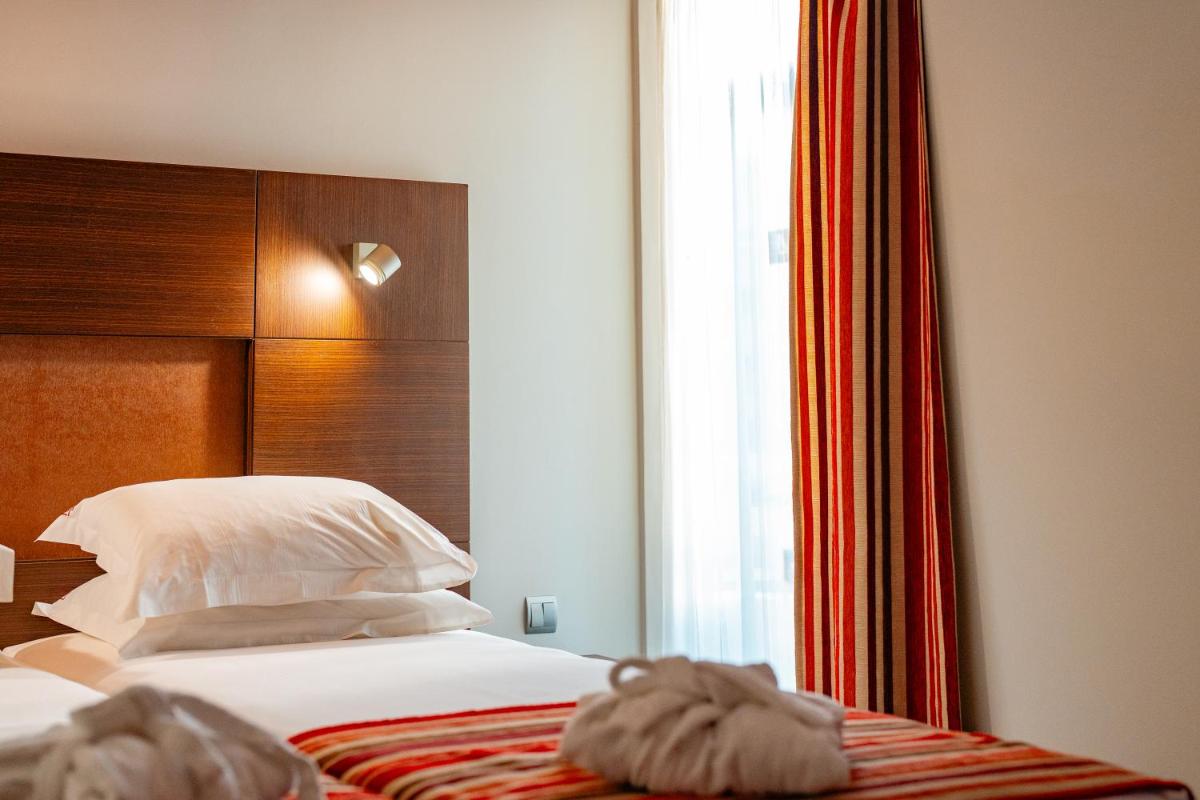 Uma cama ou camas num quarto em Muthu Raga Madeira Hotel