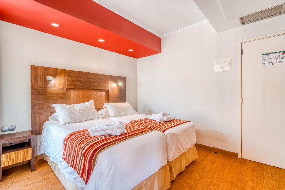 Uma cama ou camas num quarto em Muthu Raga Madeira Hotel