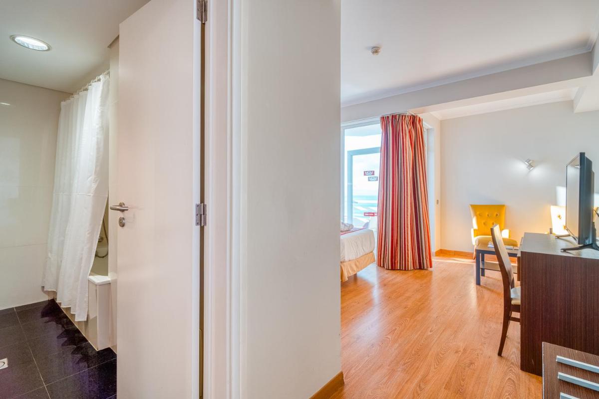 Uma televisão e/ou sistema de entretenimento em Muthu Raga Madeira Hotel