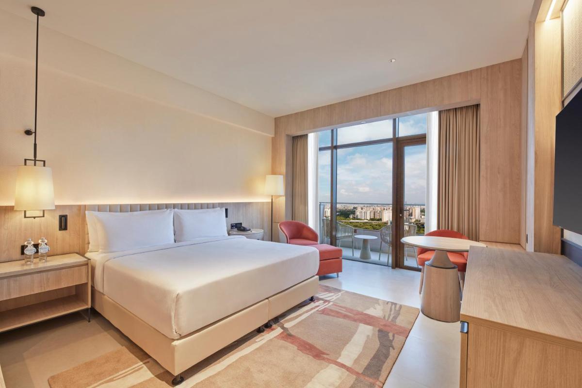 a hotel room with a bed and a large window at Hilton Gurugram Baani City Centre in Gurgaon