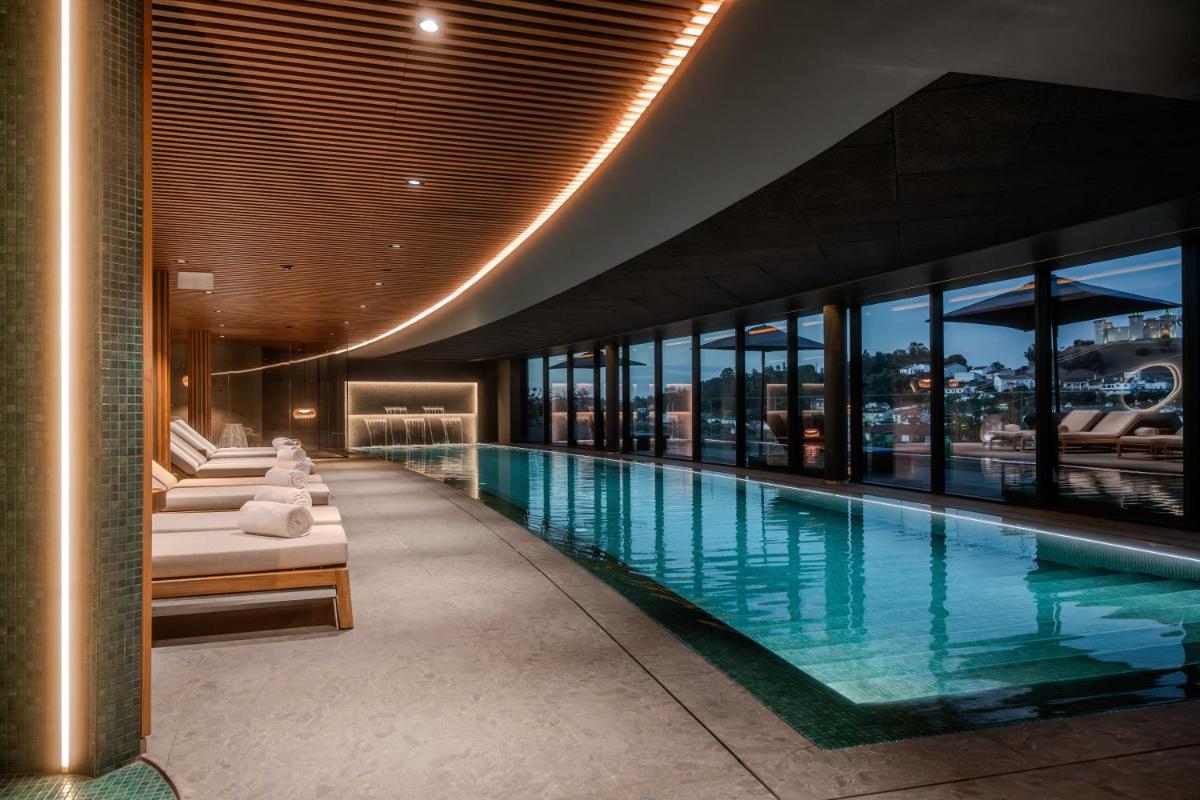 uma piscina num edifício com um grande edifício em Dolinas Climbing Hotel em Porto de Mós