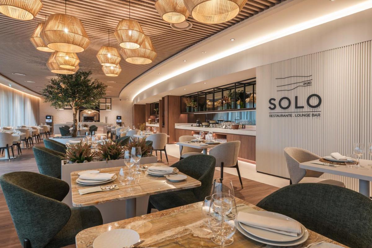 um restaurante com mesas e cadeiras e uma placa que diz solo em Dolinas Climbing Hotel em Porto de Mós