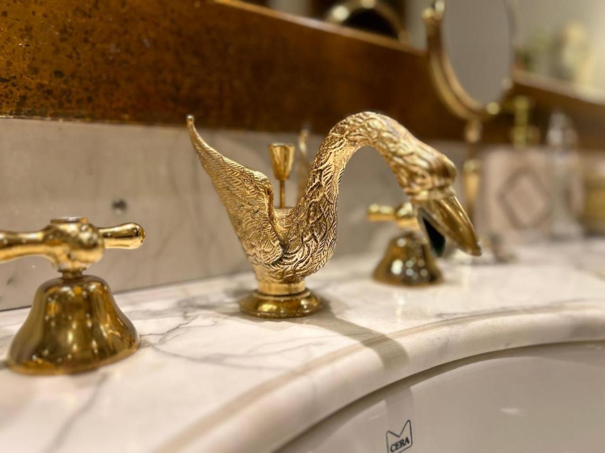 two gold faucets on top of a bathroom sink at The Raj Palace (Small Luxury Hotels of the World) in Jaipur