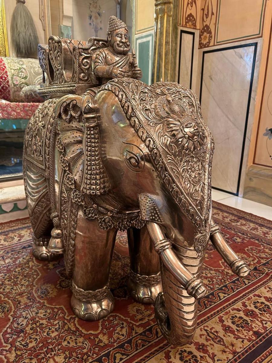 a gold elephant statue on a rug in a room at The Raj Palace (Small Luxury Hotels of the World) in Jaipur