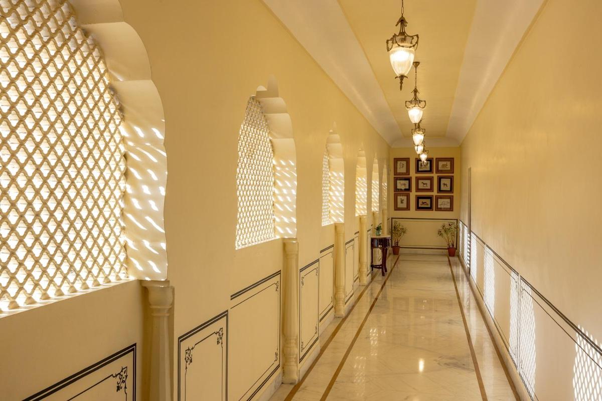 a hallway of a building with sunlight streaming through windows at Royal Heritage Haveli - By Leisure Hotels in Jaipur
