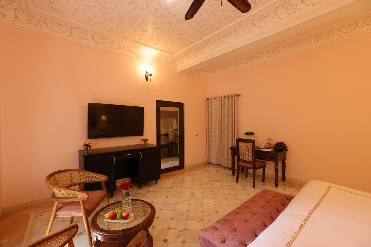 a living room with a couch and a flat screen tv at Royal Heritage Haveli - By Leisure Hotels in Jaipur