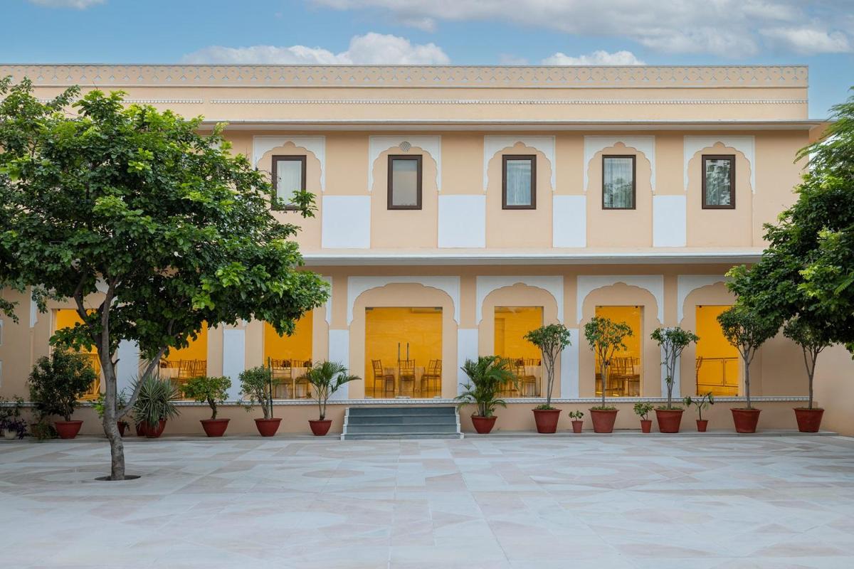 a large building with trees in front of it at Royal Heritage Haveli - By Leisure Hotels in Jaipur