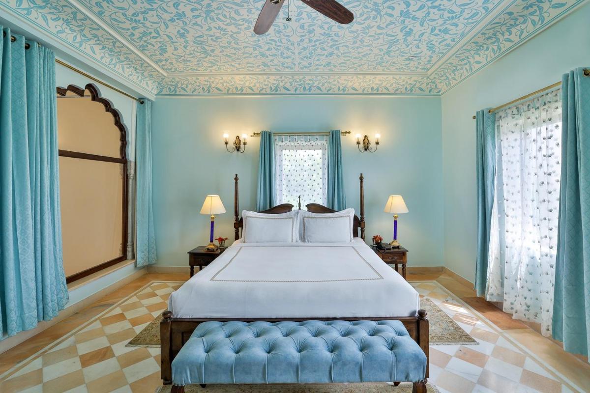 a bedroom with a bed with blue walls and a ceiling at Royal Heritage Haveli - By Leisure Hotels in Jaipur