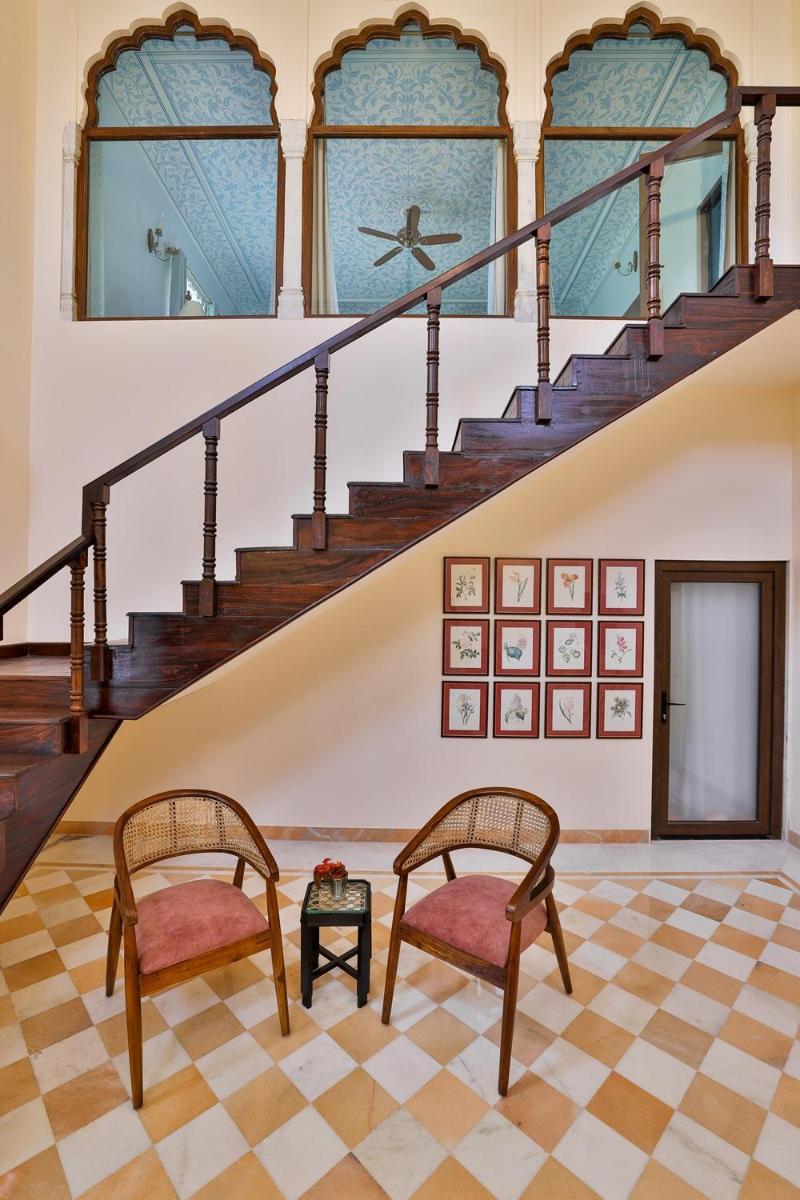 a living room with two chairs and a staircase at Royal Heritage Haveli - By Leisure Hotels in Jaipur