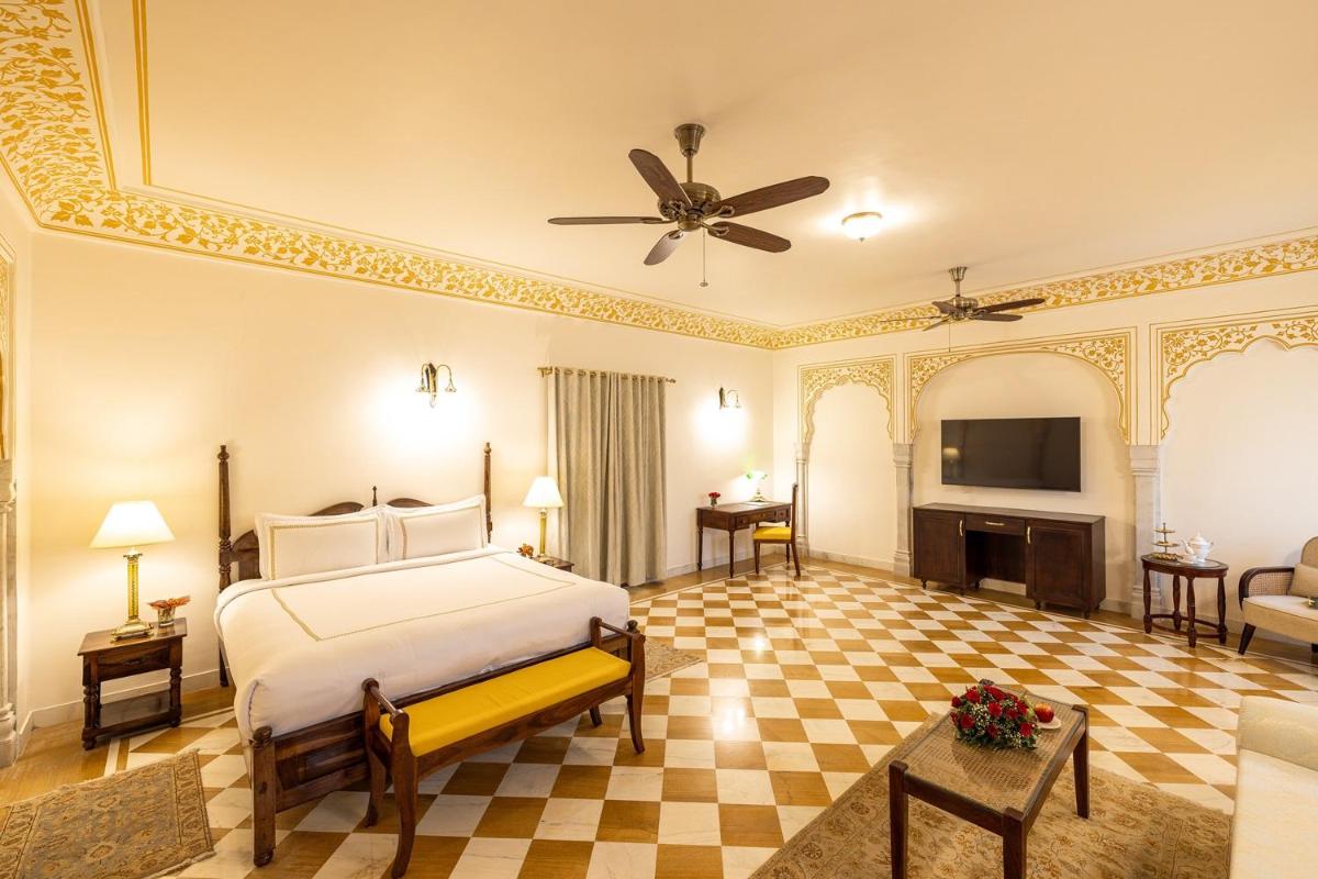 a bedroom with a bed and a living room at Royal Heritage Haveli - By Leisure Hotels in Jaipur