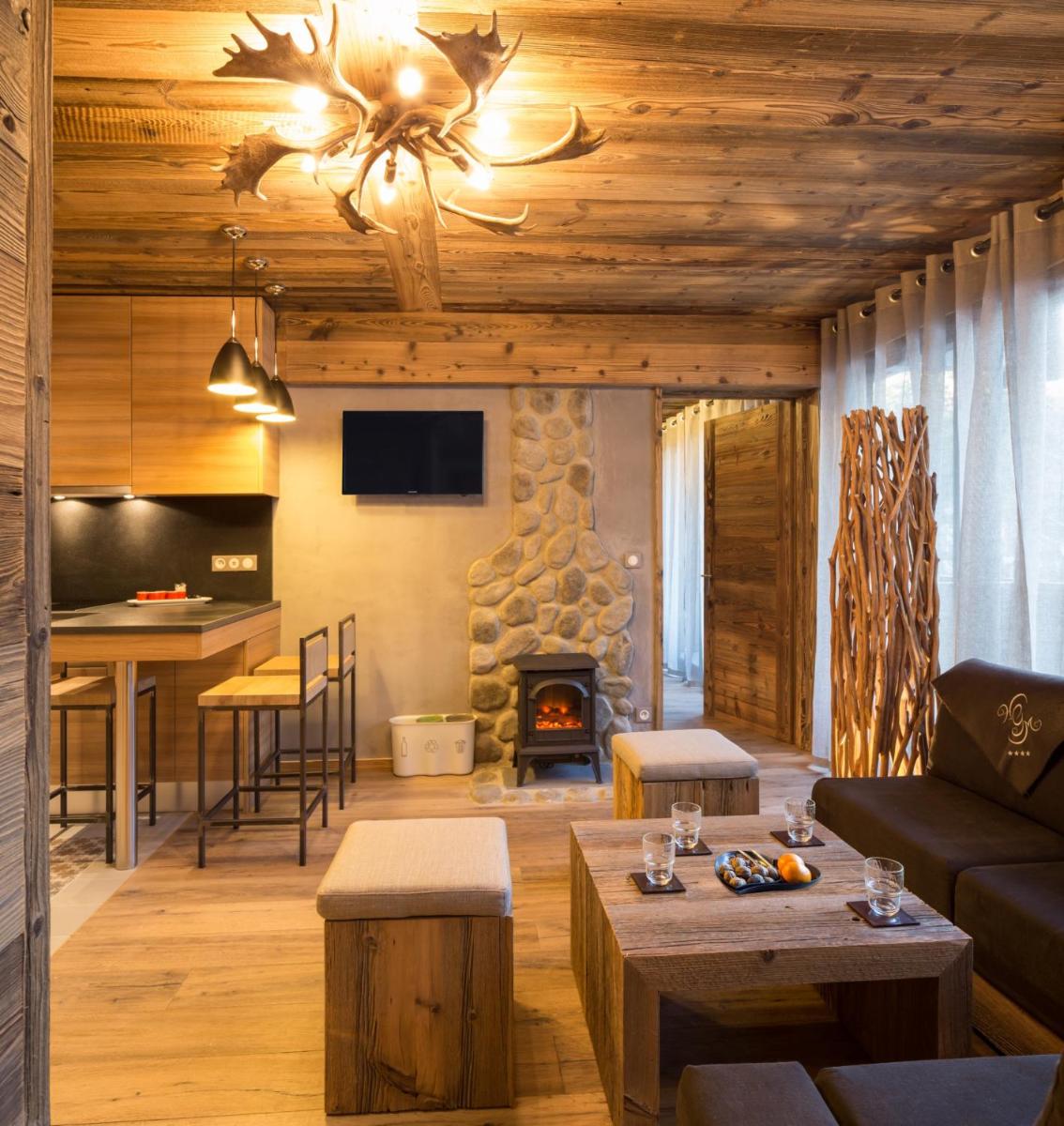 un salon avec un canapé et une cheminée dans l'établissement Les Grands Montets Hotel & Spa, à Chamonix-Mont-Blanc
