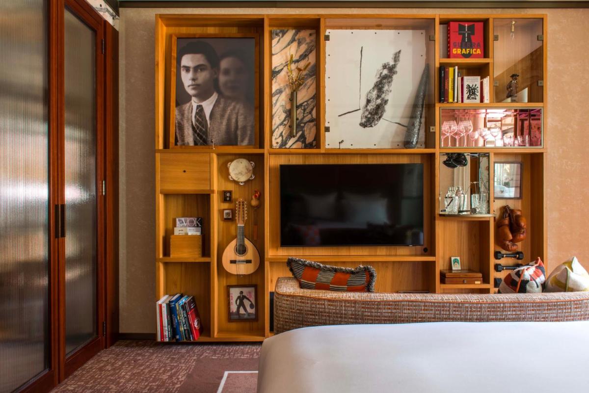 Una sala de estar con un centro de entretenimiento con televisión. en Brach Madrid - Evok Collection, en Madrid