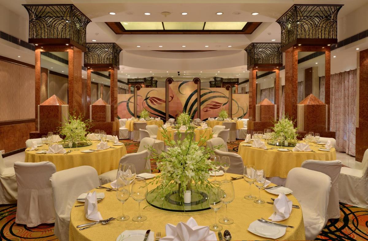 a dining room with tables with yellow tablecloths at Hotel Marine Plaza in Mumbai