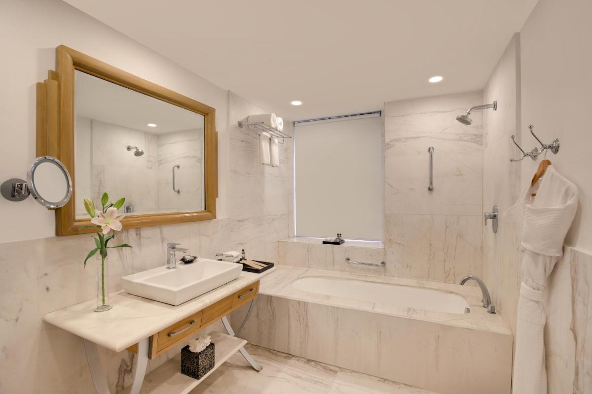 a bathroom with a tub and a sink and a shower at Ambassador, New Delhi - IHCL SeleQtions in New Delhi a bathroom with a tub and a sink and a shower at Ambassador, New Delhi - IHCL SeleQtions in New Delhi