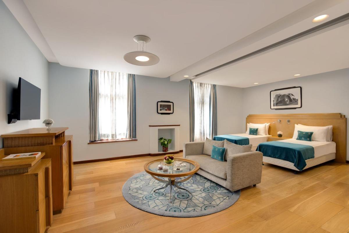 a hotel room with a bed and a couch and a table at Ambassador, New Delhi - IHCL SeleQtions in New Delhi a hotel room with a bed and a couch and a table at Ambassador, New Delhi - IHCL SeleQtions in New Delhi