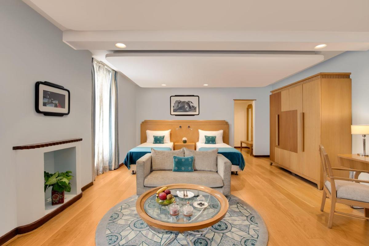 a hotel room with a bed and a couch at Ambassador, New Delhi - IHCL SeleQtions in New Delhi a hotel room with a bed and a couch at Ambassador, New Delhi - IHCL SeleQtions in New Delhi