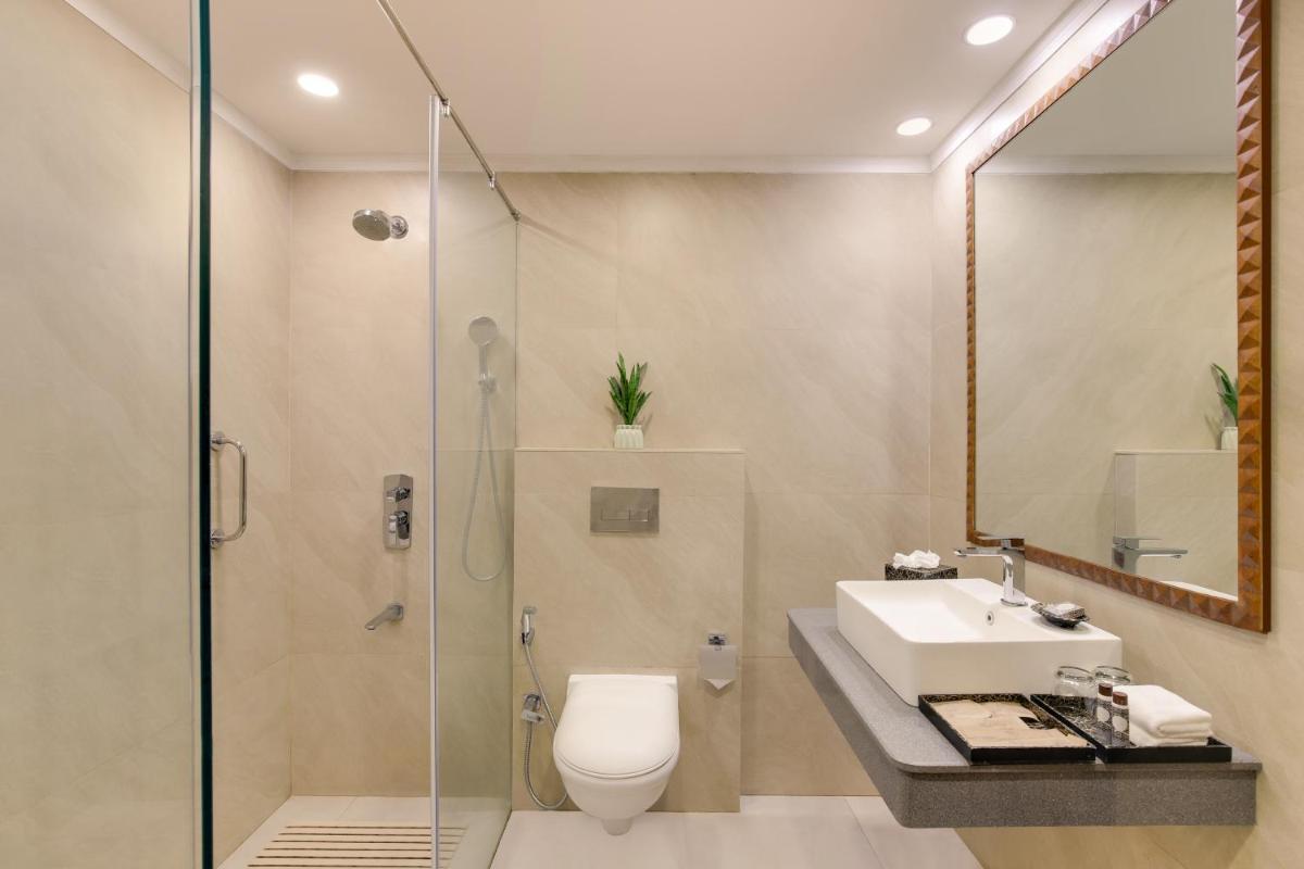 a bathroom with a shower and a toilet and a sink at Ambassador, New Delhi - IHCL SeleQtions in New Delhi a bathroom with a shower and a toilet and a sink at Ambassador, New Delhi - IHCL SeleQtions in New Delhi