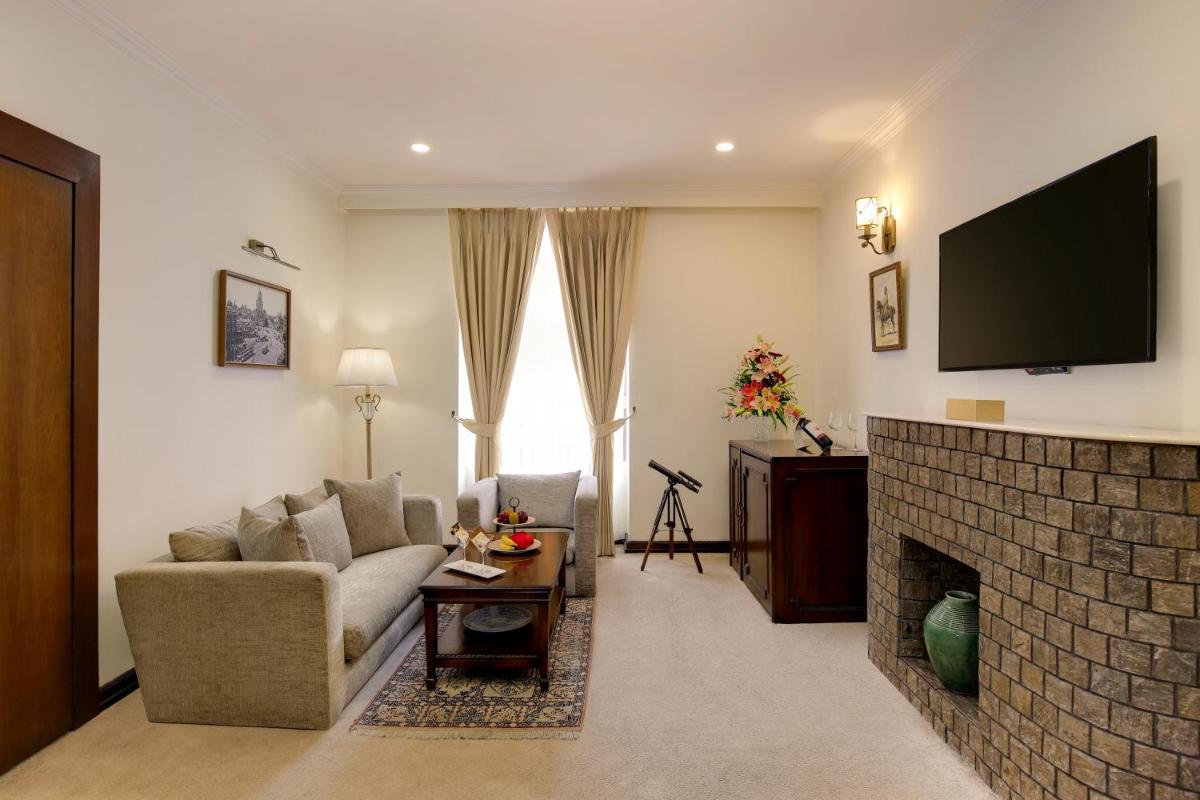 a living room with a couch and a fireplace at Ambassador, New Delhi - IHCL SeleQtions in New Delhi a living room with a couch and a fireplace at Ambassador, New Delhi - IHCL SeleQtions in New Delhi